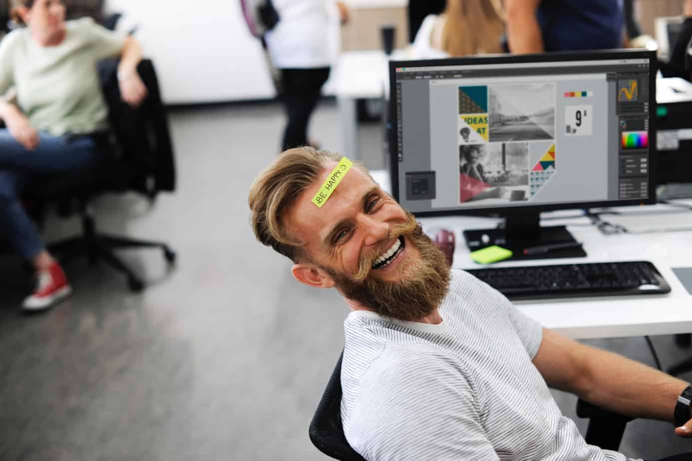 Laughing man sitting in front of a computer