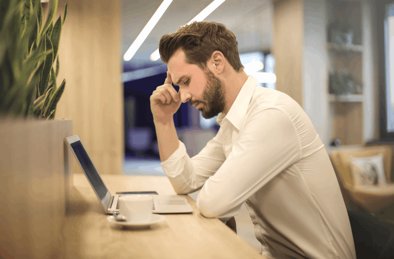 A puzzled man studies his laptop