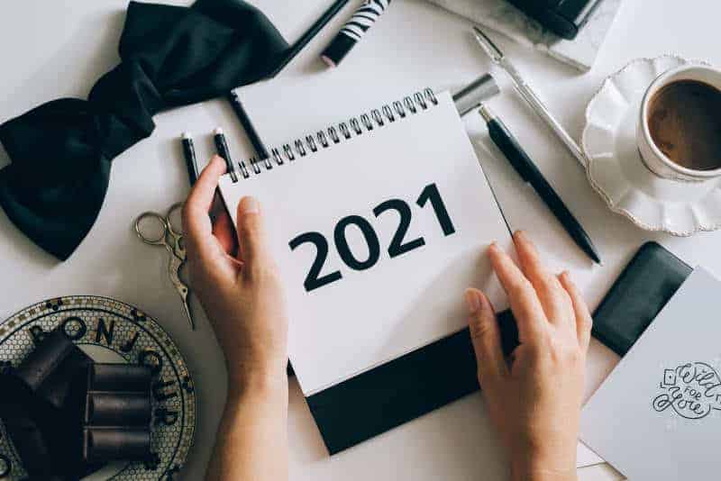 Person planning for 2021 in a notebook