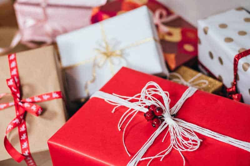 Many festive presents on a table, signifying the presents the charity will deliver