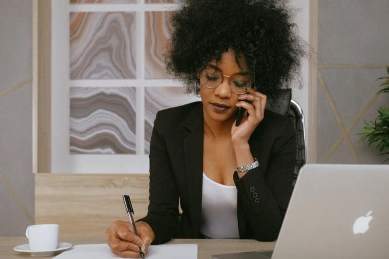 Woman on phone and sitting at desk making decisions