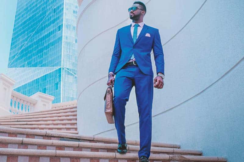 Man in a blue suit on a staircase outside