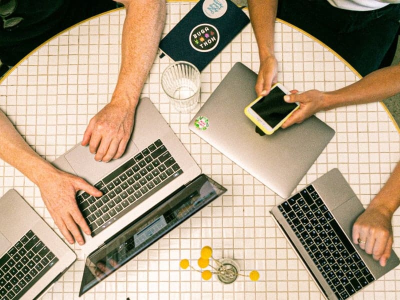 VSA, Inc. – Cooperation Many hands and electronics at a table