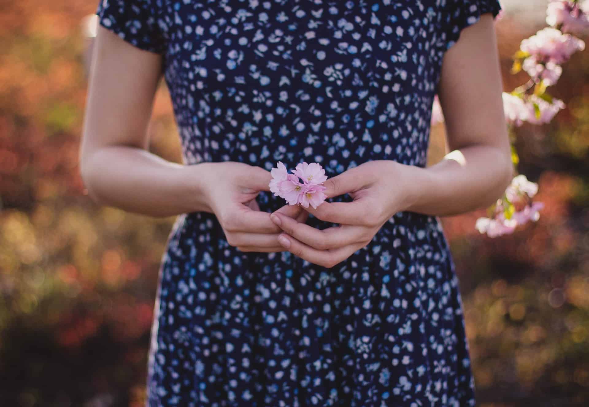 Woman in dress holding pink flower