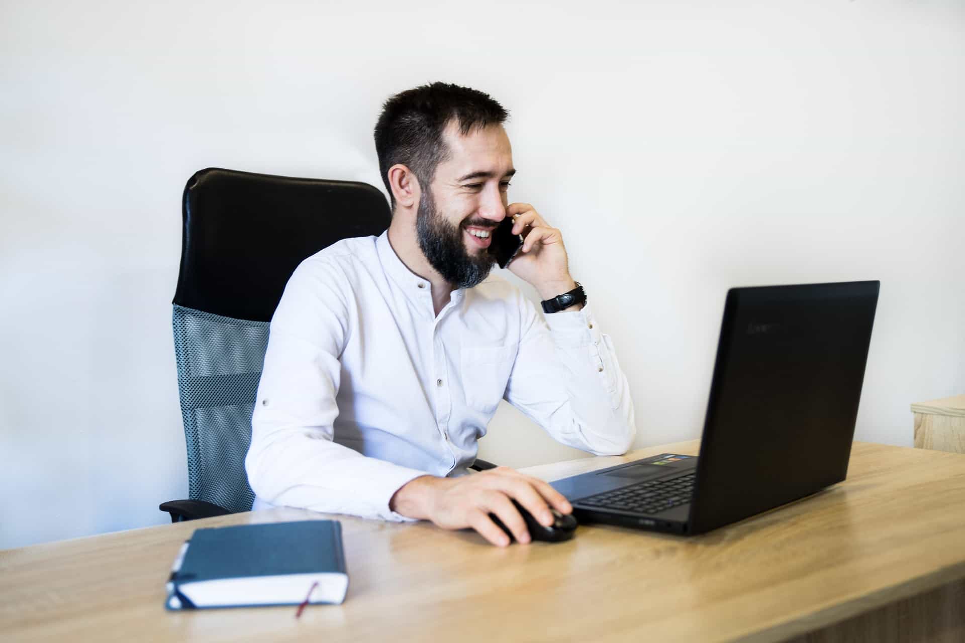 Man in office on phone with a smile.